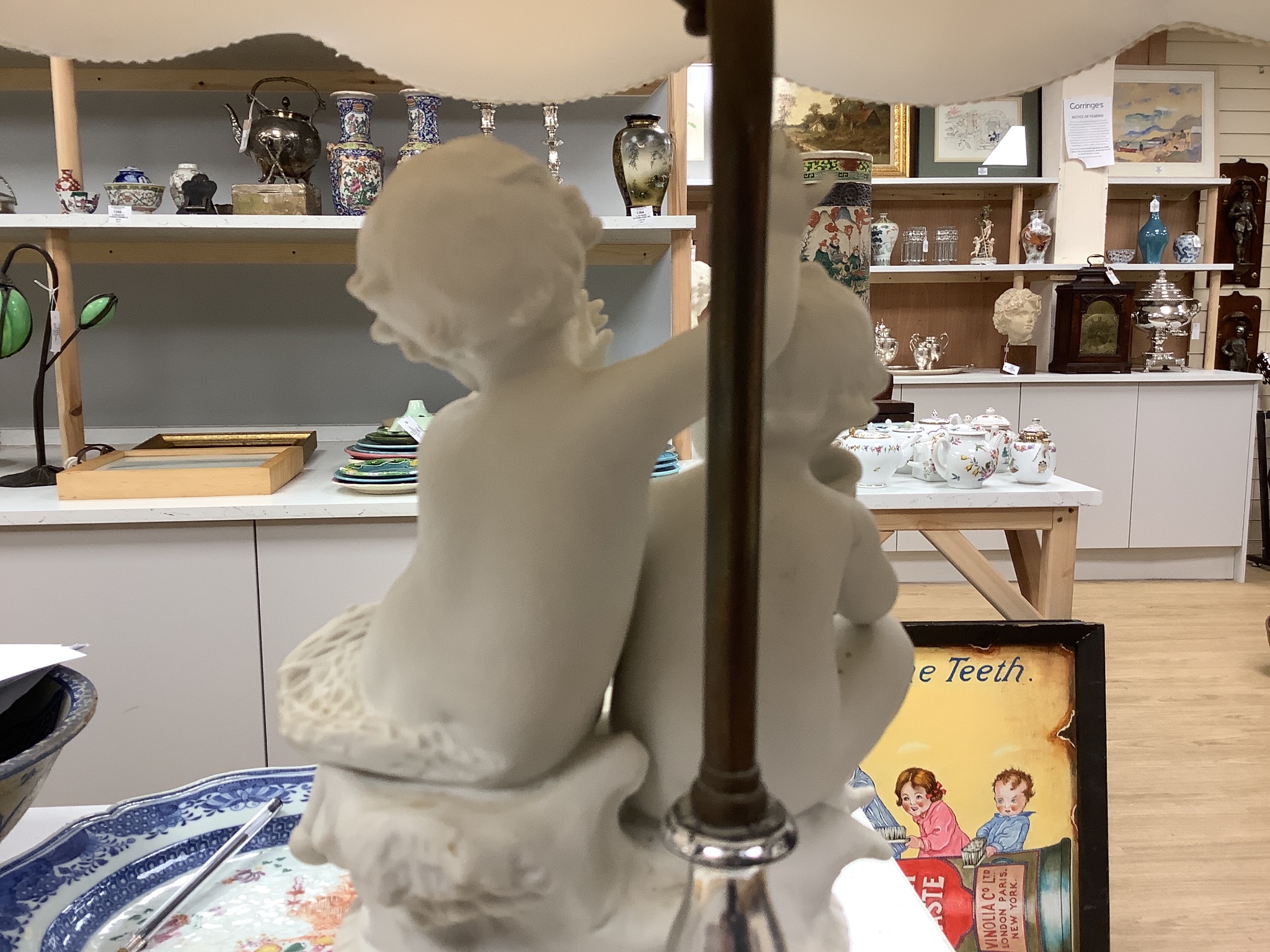 A pair of Sevres style biscuit porcelain groups of putti, fitted as a table lamps with shades 69cm total height incl shades